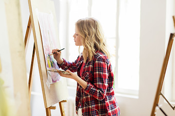 Image showing student girl with easel painting at art school