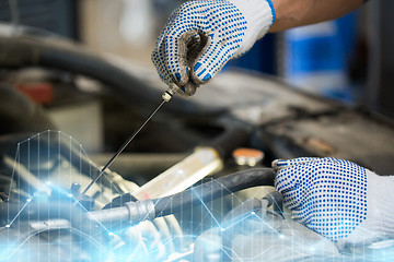 Image showing mechanic with dipstick checking motor oil level