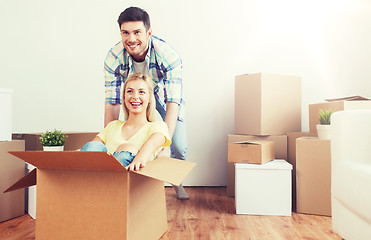 Image showing happy couple having fun with boxes at new home