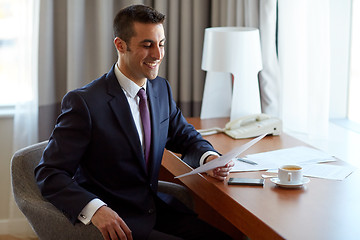 Image showing businessman with papers working at hotel room