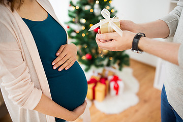 Image showing husband giving christmas present to pregnant wife