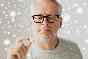 Image showing close up of senior man taking medicine pill