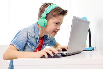 Image showing boy in headphones playing video game on laptop