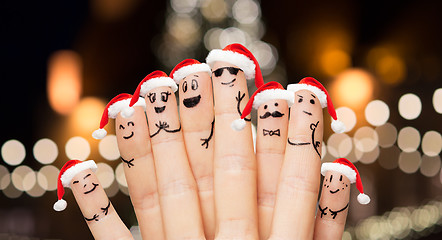 Image showing close up of fingers in santa hats at christmas