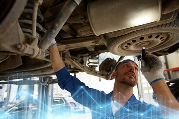 Image showing mechanic man with flashlight repairing car at shop