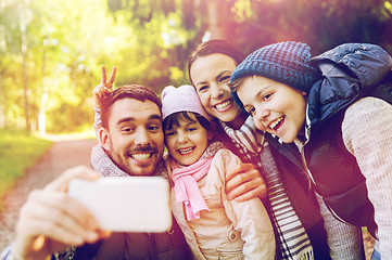 Image showing happy family taking selfie by smartphone outdoors