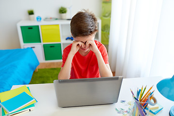 Image showing tired student boy with laptop computer at home