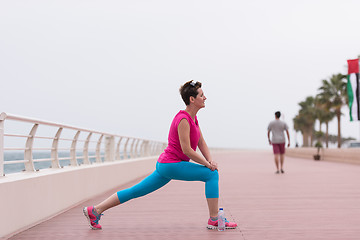 Image showing woman stretching and warming up on the promenade