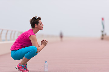 Image showing woman stretching and warming up on the promenade