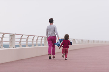 Image showing mother and cute little girl on the promenade by the sea