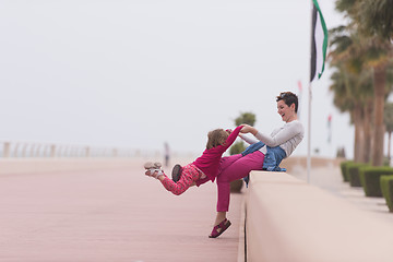 Image showing mother and cute little girl on the promenade by the sea