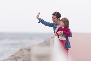 Image showing mother and cute little girl on the promenade by the sea