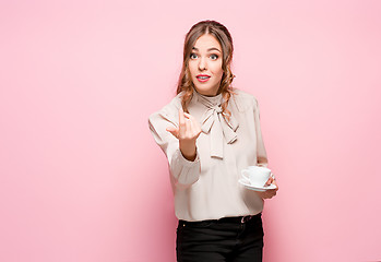 Image showing The serious frustrated young beautiful business woman on pink background