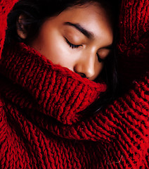 Image showing young pretty indian mulatto girl in red sweater posing emotional, fashion hipster teenage, lifestyle people concept closeup