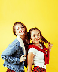 Image showing lifestyle people concept: two pretty young school teenage girls having fun happy smiling on yellow background 