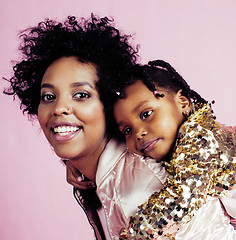 Image showing young pretty african-american mother with little cute daughter hugging, happy smiling on pink background, lifestyle modern people concept closeup