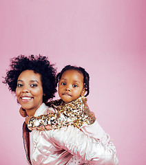 Image showing young pretty african-american mother with little cute daughter hugging, happy smiling on pink background, lifestyle modern people concept closeup