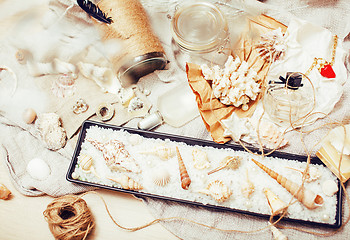 Image showing a lot of sea theme in mess like shells, candles, perfume, girl s