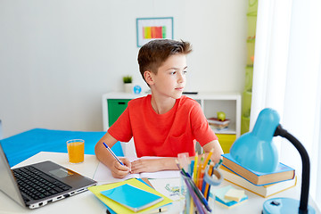 Image showing student boy with laptop writing to notebook