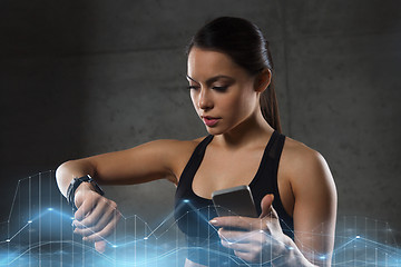 Image showing woman with heart-rate watch and smartphone in gym