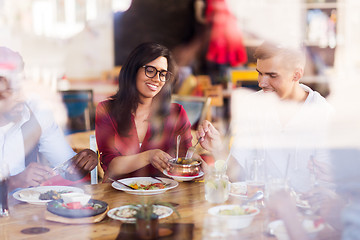 Image showing happy friends eating at restaurant