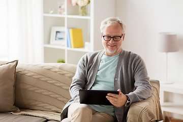 Image showing senior man with tablet pc sitting on sofa at home