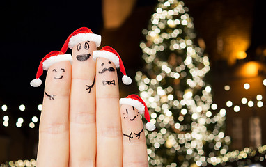 Image showing close up of fingers in santa hats at christmas