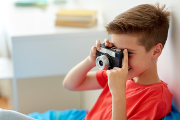 Image showing happy boy with film camera photographing at home