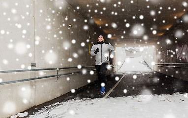Image showing happy man running along subway tunnel in winter