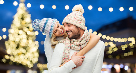 Image showing happy couple hugging over christmas tree lights