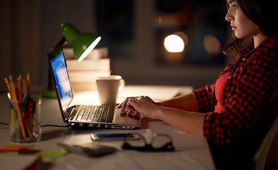 Image showing student or woman typing on laptop at night home