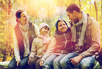 Image showing happy family sitting on bench and talking at camp