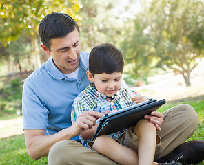 Image showing Happy Father and Son Playing on a Computer Tablet Outside.