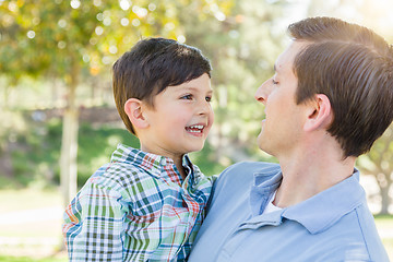 Image showing Happy Caucasian Father and Son Playing Together in the Park.