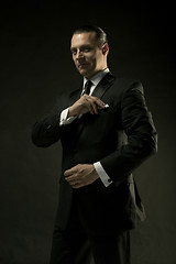 Image showing The attractive man in black suit on dark background