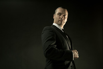 Image showing The attractive man in black suit on dark background