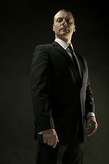 Image showing The attractive man in black suit on dark background