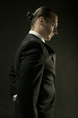 Image showing The attractive man in black suit on dark background