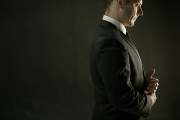 Image showing The attractive man in black suit on dark background