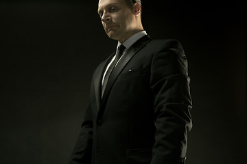 Image showing The attractive man in black suit on dark background