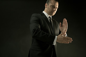 Image showing The attractive man in black suit on dark background