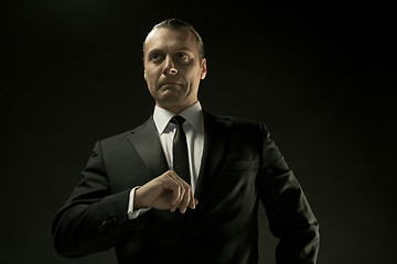 Image showing The attractive man in black suit on dark background