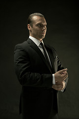 Image showing The attractive man in black suit on dark background