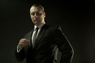 Image showing The attractive man in black suit on dark background