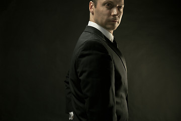 Image showing The attractive man in black suit on dark background