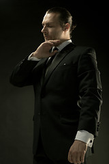 Image showing The attractive man in black suit on dark background