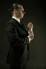 Image showing The attractive man in black suit on dark background