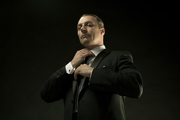 Image showing The attractive man in black suit on dark background