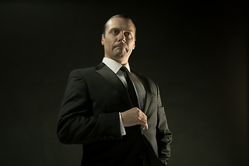 Image showing The attractive man in black suit on dark background