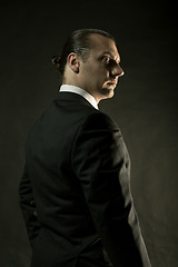 Image showing The attractive man in black suit on dark background